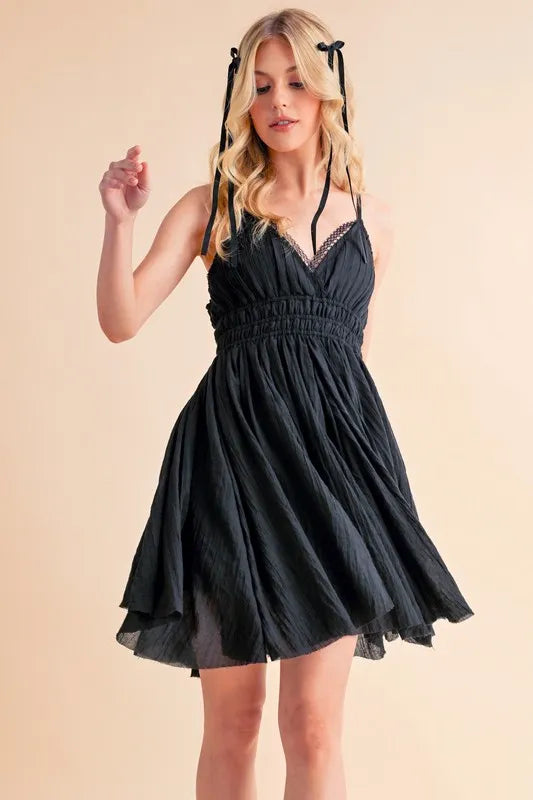 Black Aemi+Co lace detail mini cami dress by Trendsi, featuring delicate lace accents and a fitted sleeveless design.