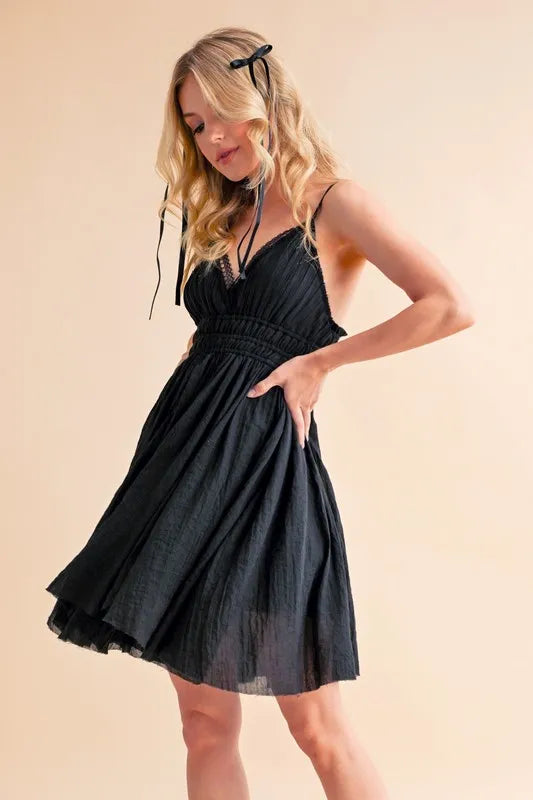 Black Aemi+Co lace detail mini cami dress with thin straps, fitted silhouette, and delicate lace accents for stylish summer wear.