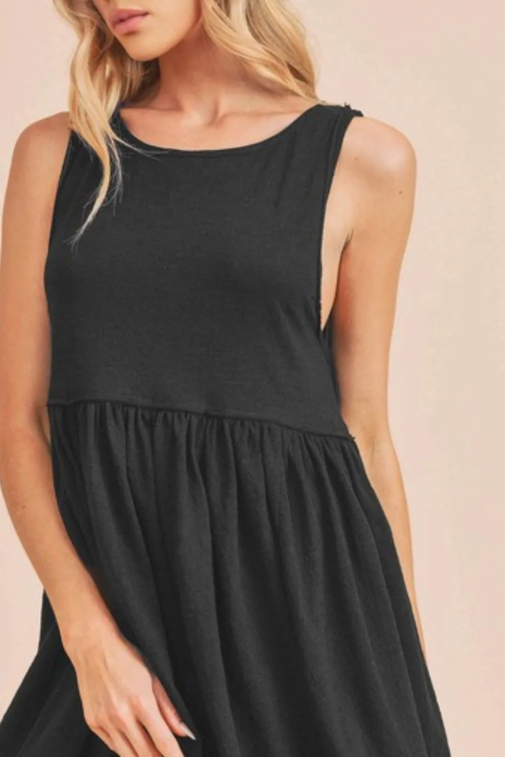 Black Aemi + Co round neck mini tank dress from Trendsi, featuring a simple sleeveless design and fitted silhouette.