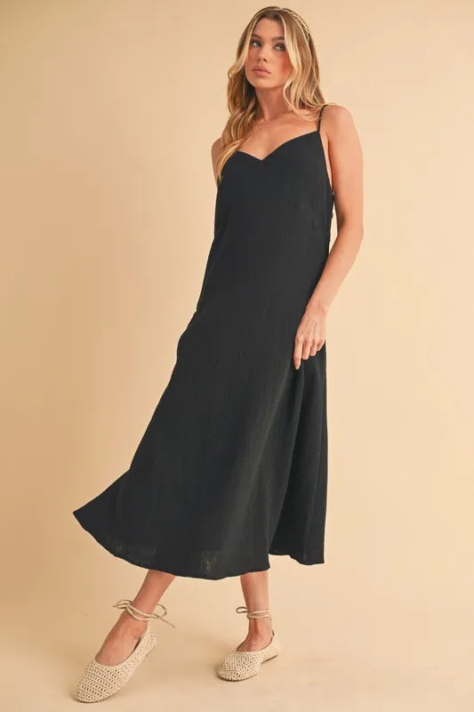 Black Aemi+Co side button midi cami dress by Trendsi, featuring a sleeveless design, button details, and a midi length.