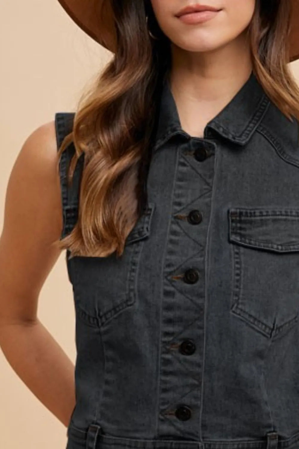 Black Annie Wear denim vest with a collared neck and button-down front, styled with visible stitching and sleeveless design.