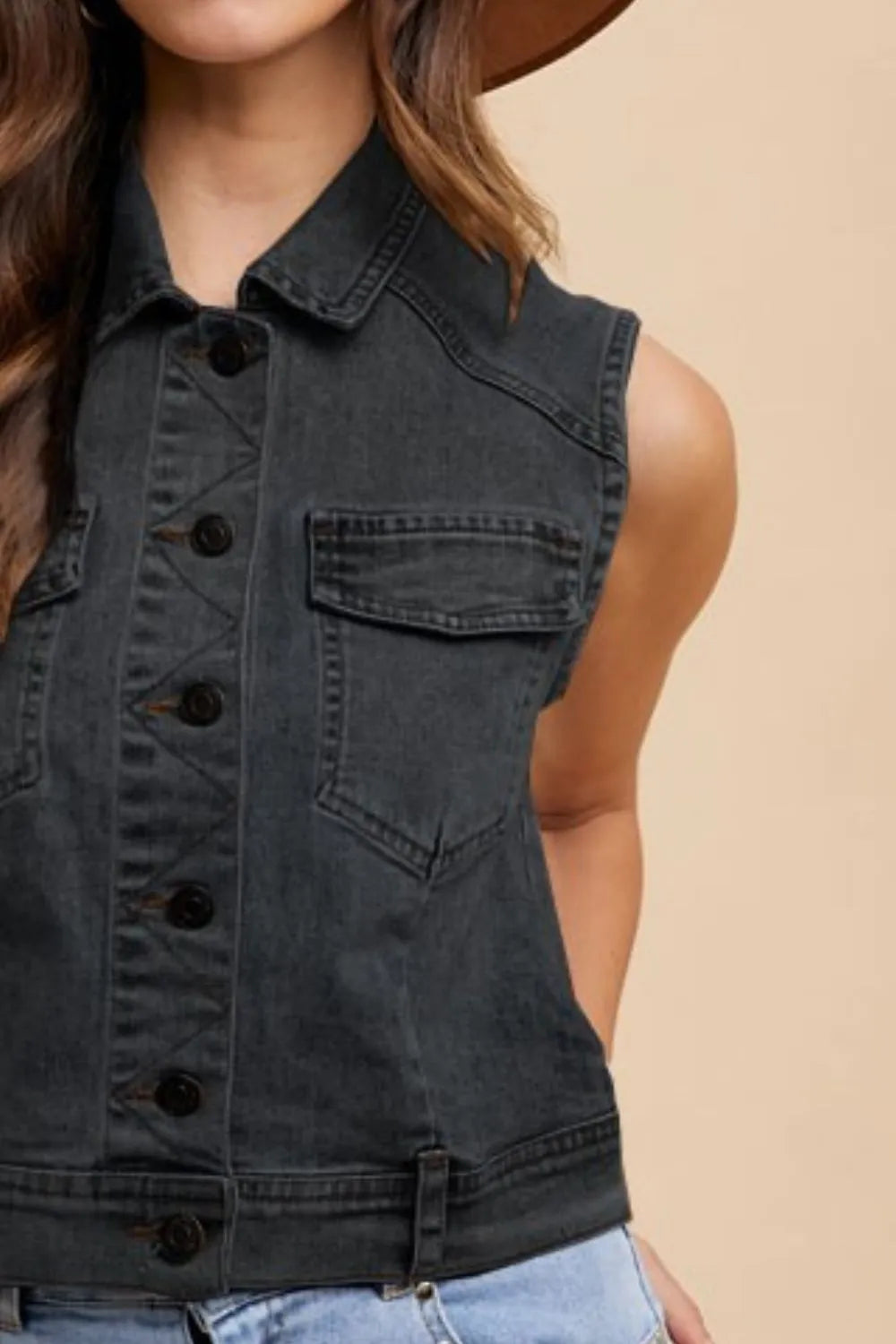 Black Annie Wear denim vest with a collared neck and button-down front, styled with visible stitching and classic denim texture.