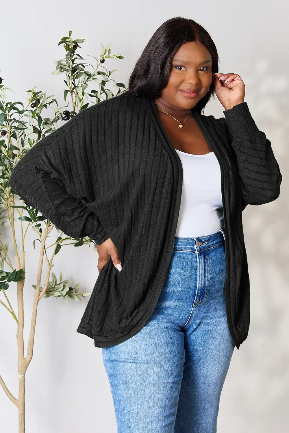 Black Trendsi Basic Bae Full Size Ribbed Cocoon Cardigan displayed on a hanger, showcasing its cozy, oversized fit and ribbed texture.