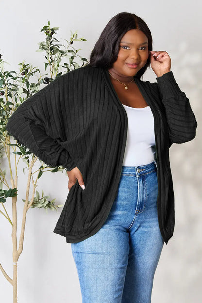 Black Trendsi Basic Bae Full Size Ribbed Cocoon Cardigan displayed on a hanger, showcasing its cozy, oversized fit and ribbed texture.