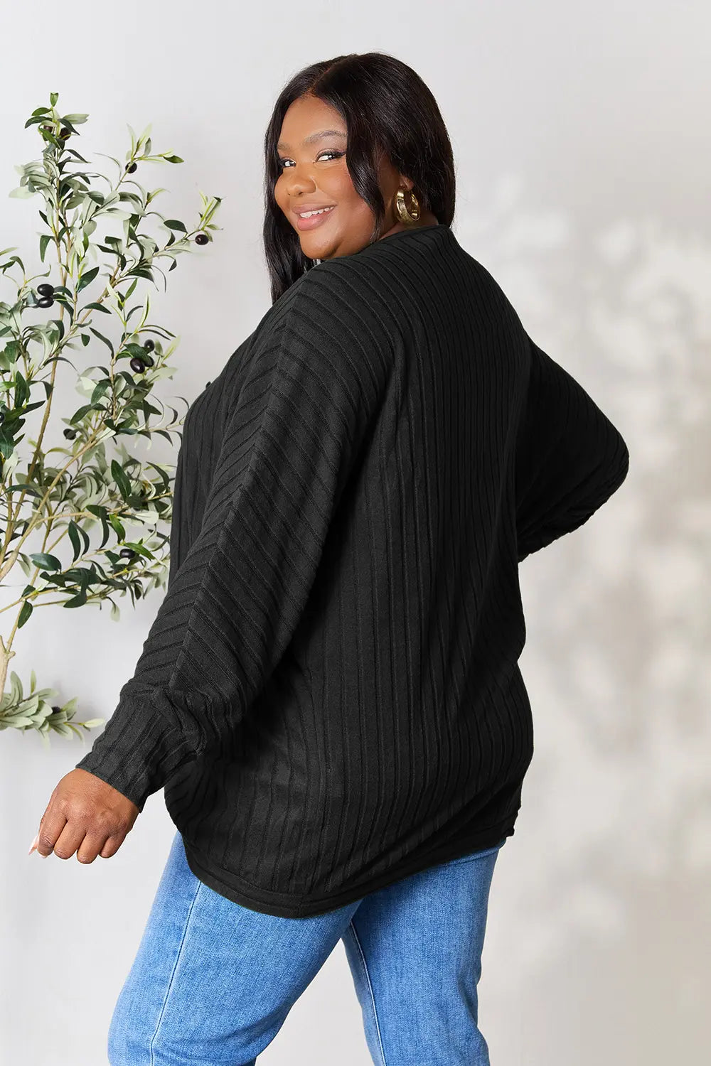 Black Basic Bae Full Size Ribbed Cocoon Cardigan by Trendsi, shown on a model, featuring a cozy, oversized fit and textured knit fabric.