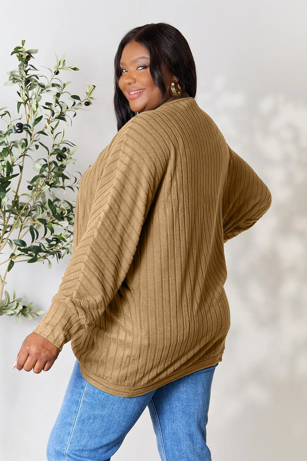 Black Trendsi Basic Bae full-size ribbed cocoon cardigan hanging on a hanger, showcasing its relaxed fit and textured knit fabric.