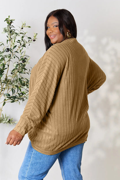Black Trendsi Basic Bae full-size ribbed cocoon cardigan hanging on a hanger, showcasing its relaxed fit and textured knit fabric.