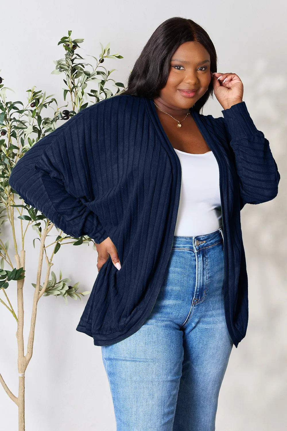 Black Trendsi Basic Bae full-size ribbed cocoon cardigan draped on a hanger, showcasing its relaxed fit and textured knit fabric.