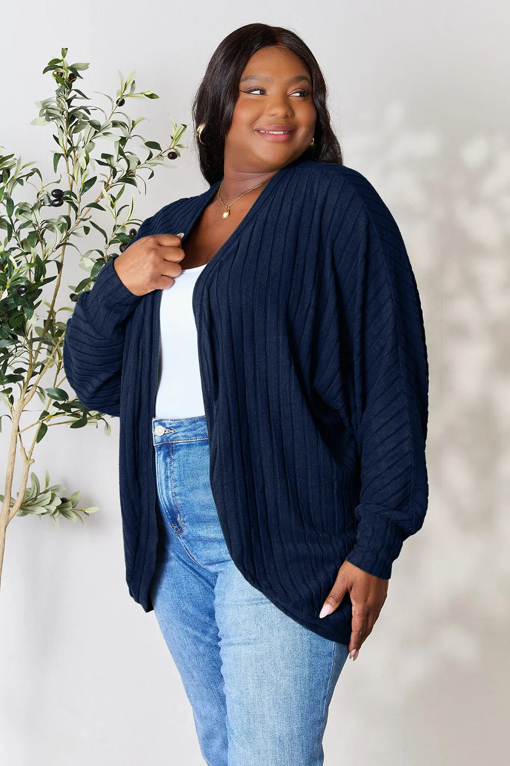 Black Trendsi Basic Bae full-size ribbed cocoon cardigan draped on a hanger, showcasing its cozy, oversized fit and textured knit fabric.