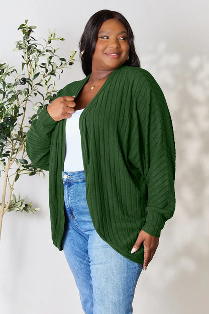 Black Trendsi Basic Bae full-size ribbed cocoon cardigan hanging on a display, showcasing its relaxed fit and textured fabric.