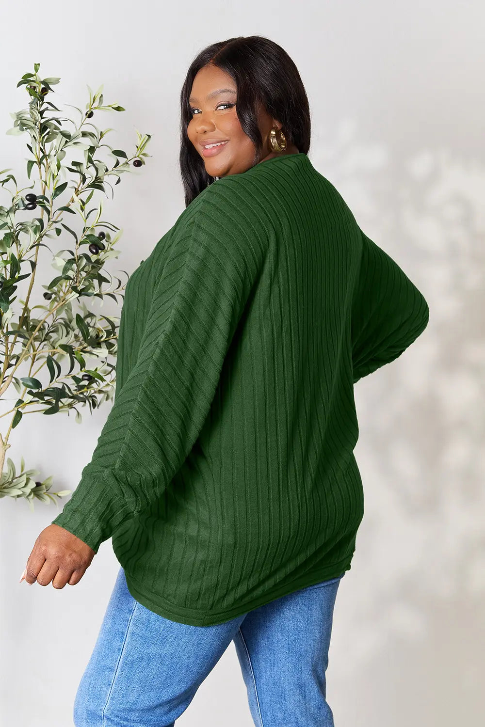 Black Trendsi Basic Bae full-size ribbed cocoon cardigan draped on a hanger, showcasing its relaxed fit and textured fabric.