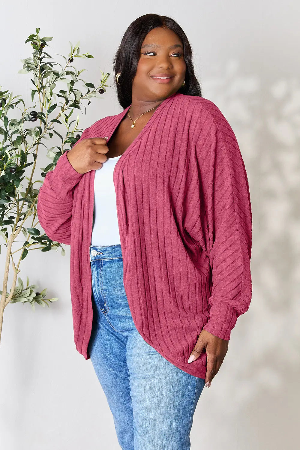 Black Trendsi Basic Bae full-size ribbed cocoon cardigan draped on a hanger, showcasing its relaxed fit and ribbed texture.