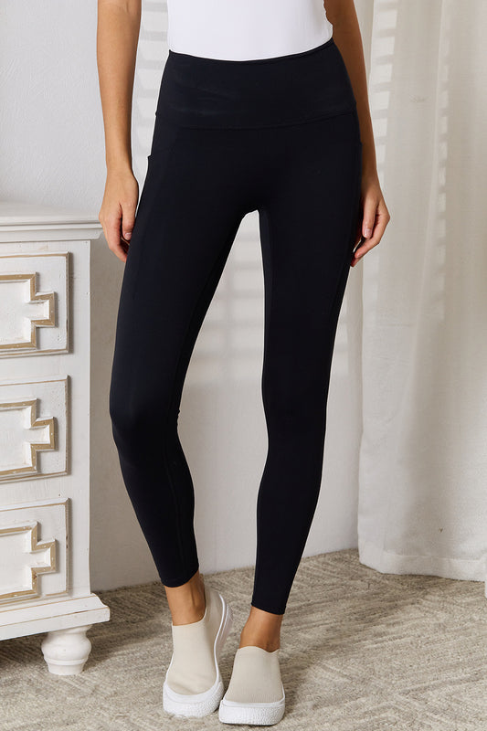 Black Basic Bae wide waistband sports leggings by Trendsi, showing a close-up of the high-rise elastic waistband and stretchy fabric.