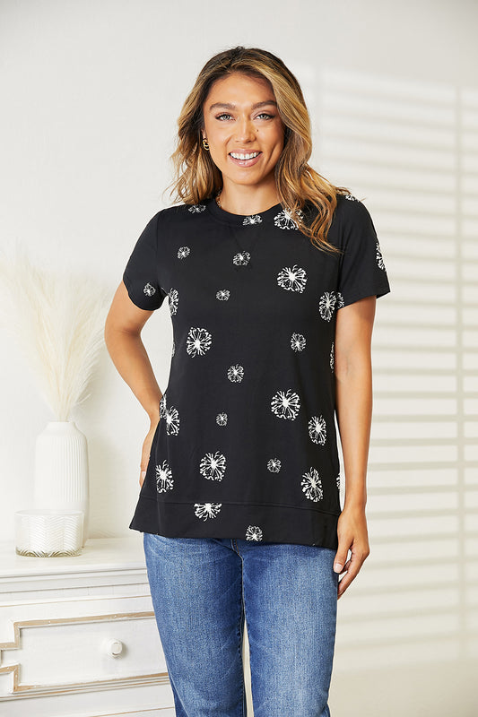 Black Trendsi Double Take Dandelion print round neck T-shirt featuring a vibrant dandelion design on soft fabric.