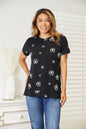 Black Trendsi Double Take Dandelion print round neck T-shirt featuring a vibrant dandelion design on soft fabric.