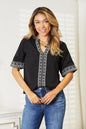 Black double take embroidered notched neck top by Trendsi, featuring intricate embroidery and a stylish notched neckline.
