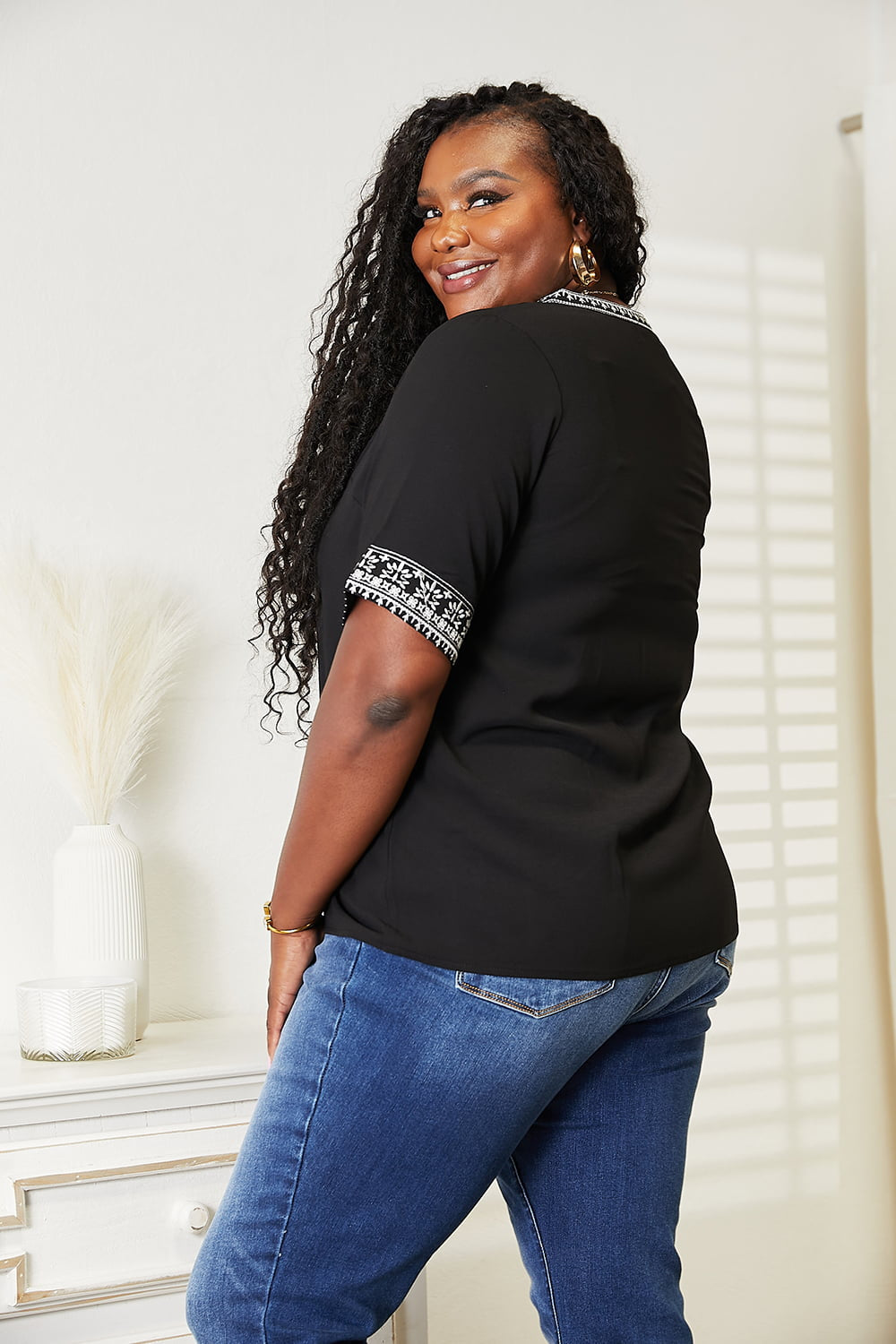 Black embroidered notched neck top from Trendsi's Double Take collection, featuring detailed embroidery and a stylish cut.