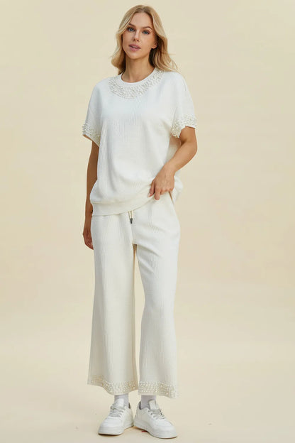 Black double take pearl detail round neck top and pants set by Trendsi, featuring elegant pearl accents and a coordinated stylish look.