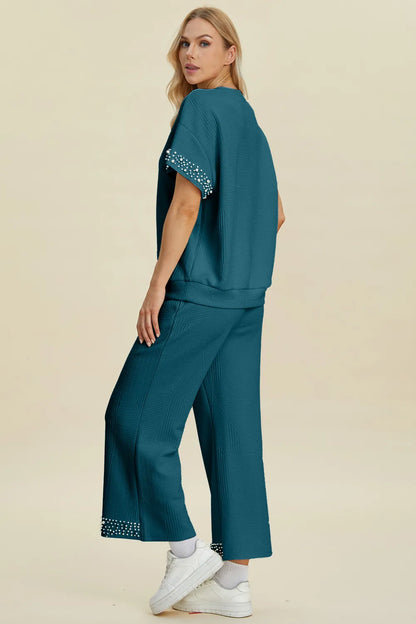 Black double take full size pearl detail round neck top and pants set by Trendsi, featuring elegant pearl accents and comfortable fit.