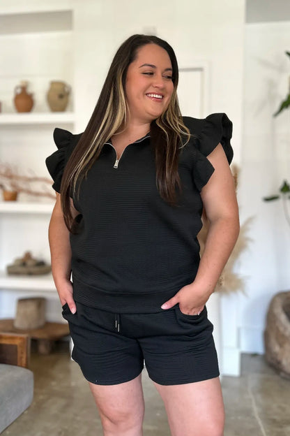 Black double take texture flounce sleeve top and shorts set by Trendsi, featuring stylish sleeves and a coordinated summer outfit.
