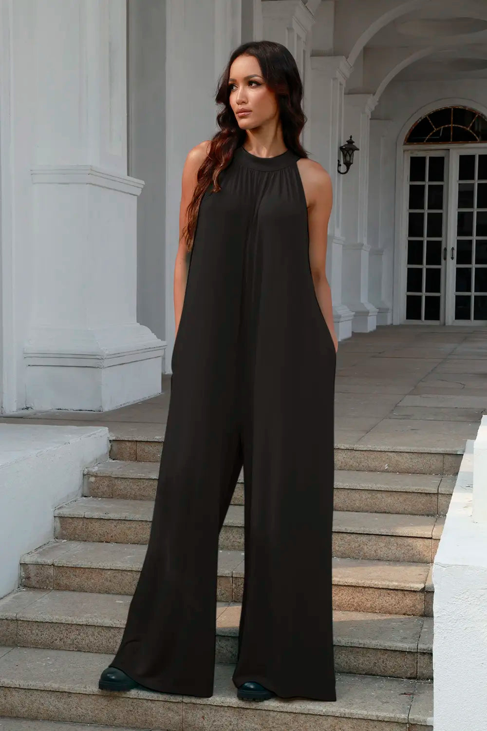 Black sleeveless jumpsuit with tie-back and cutout details, featuring a full-size fit from Trendsi.