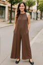 Black sleeveless jumpsuit with tie-back and cutout details, featuring a full-size fit from Trendsi.