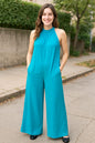 Black sleeveless jumpsuit with tie-back and cutout details, featuring a full-size fit and stylish design by Trendsi.
