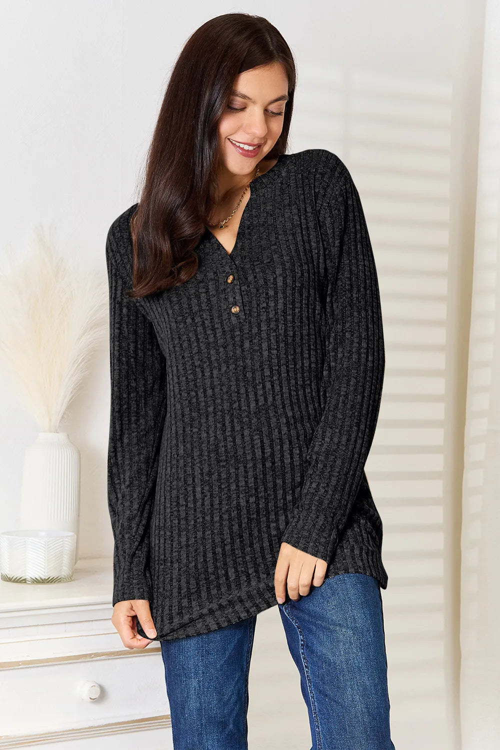 Black ribbed long sleeve T-shirt with a notched neckline by Trendsi, featuring a fitted design and long sleeves.