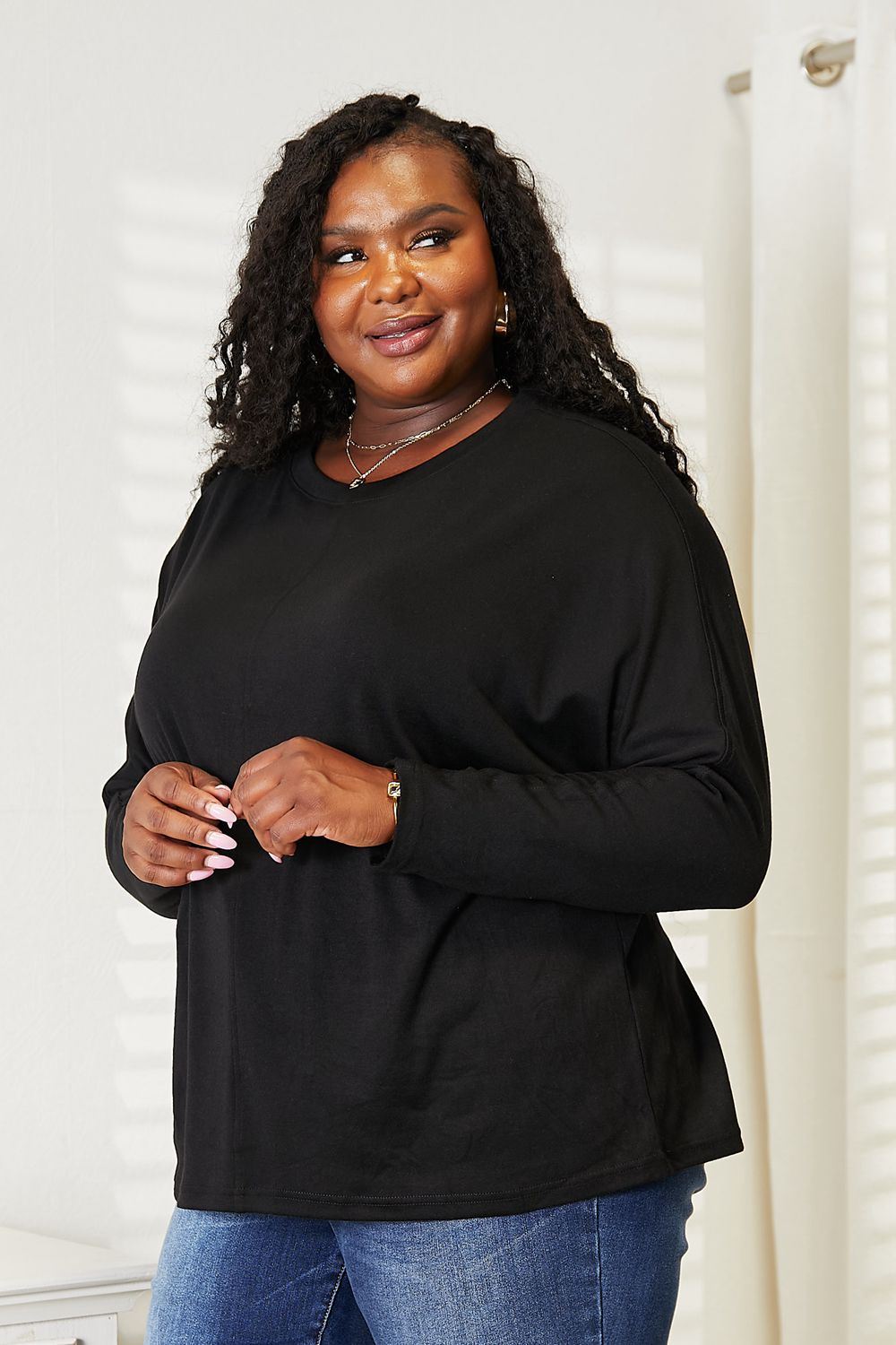 Black long sleeve top with seam details and round neckline from Trendsi's Double Take collection, shown on a hanger.