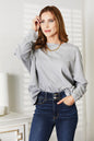 Black long sleeve top with seam details and round neckline from Trendsi's Double Take collection.