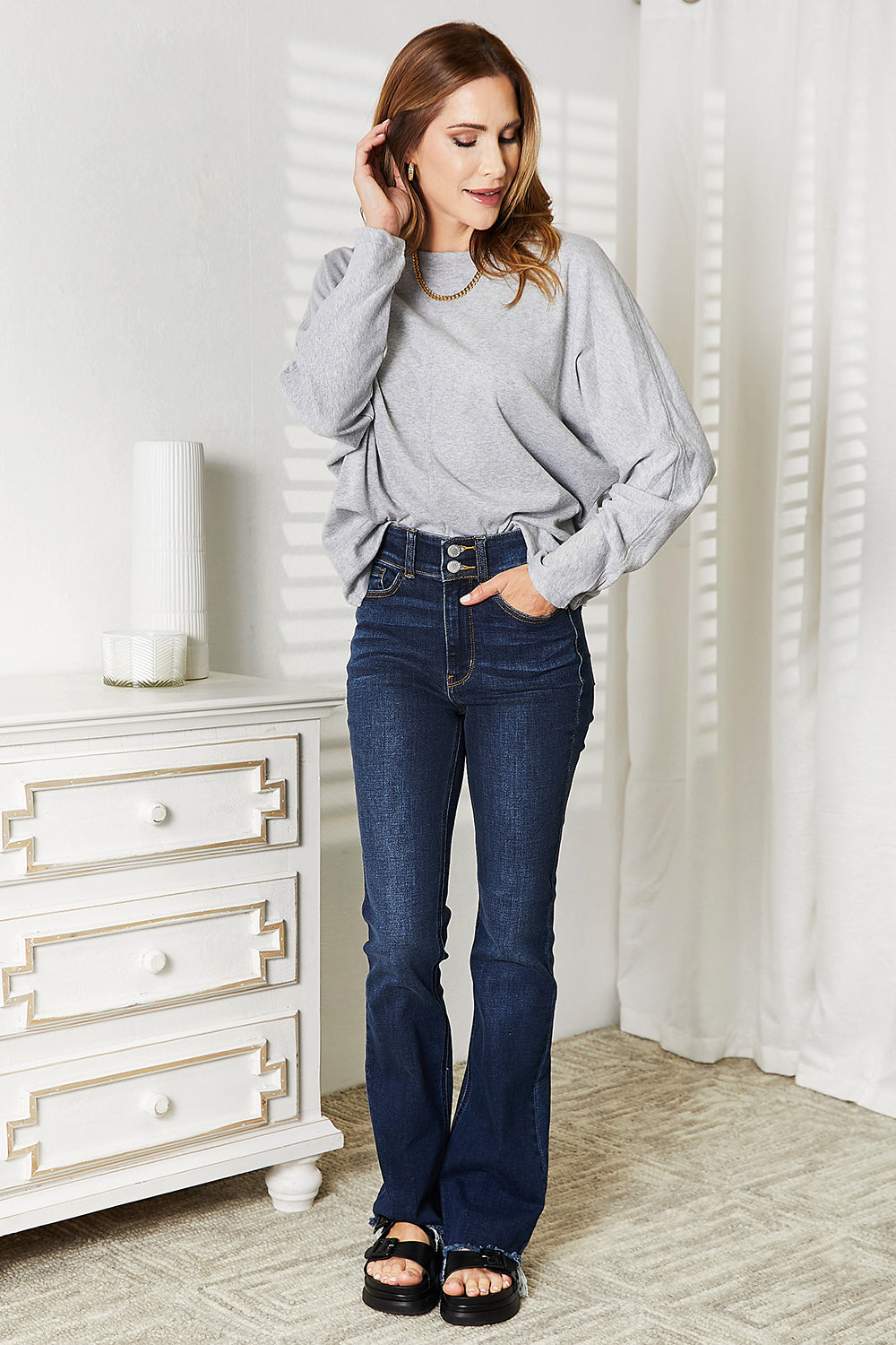 Black long sleeve top with seam detail and round neckline by Trendsi, showcasing the stylish, fitted design.