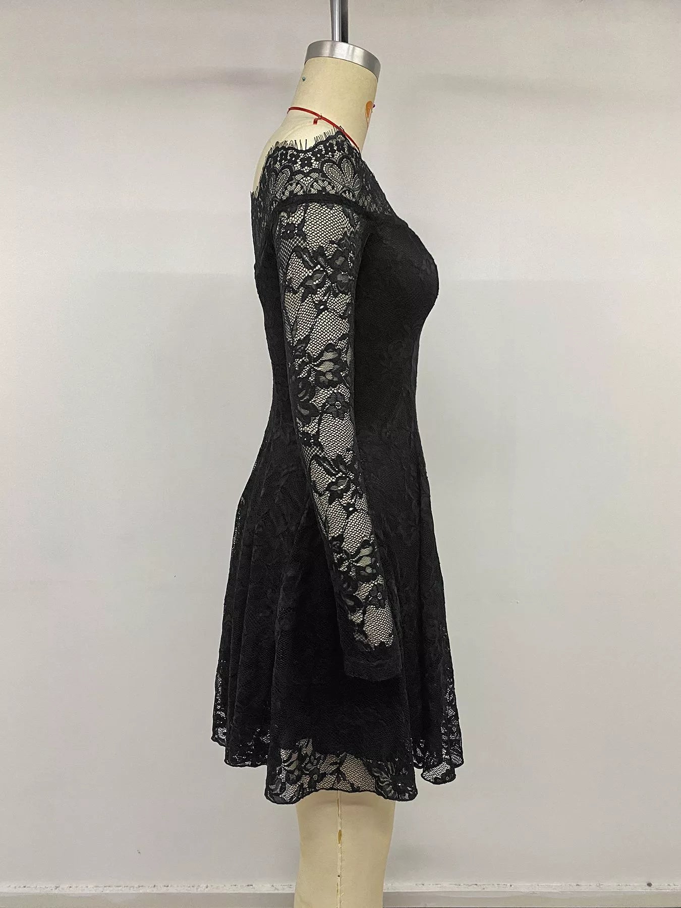 Black lace off-shoulder mini dress by Trendsi, featuring a fitted silhouette and elegant off-shoulder design.