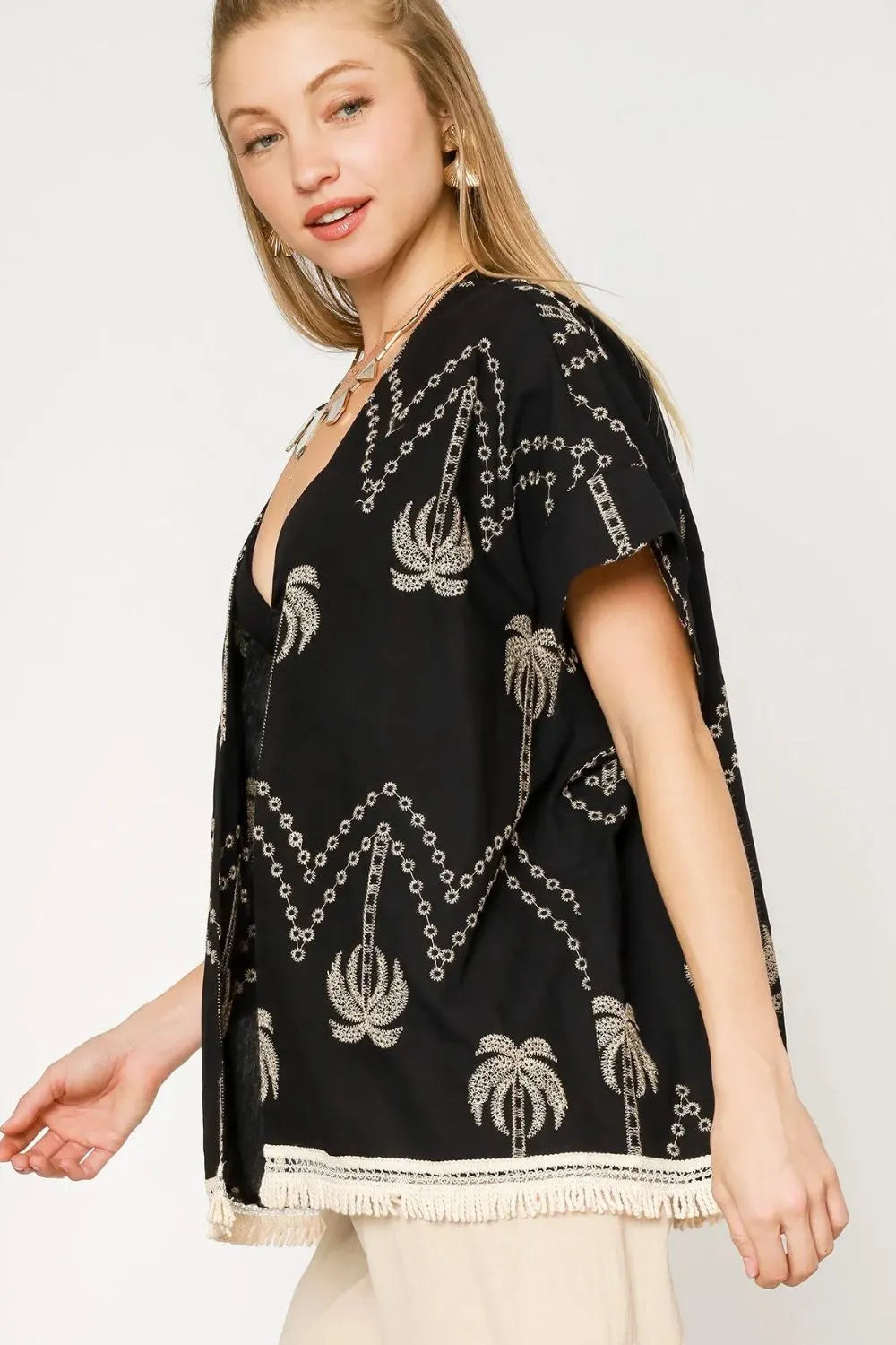 Black Umgee open front kimono with embroidered details and fringe trim, styled with flowing sleeves and lightweight fabric.