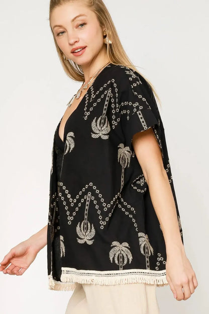 Black Umgee open front kimono with embroidered details and fringe trim, styled with flowing sleeves and lightweight fabric.