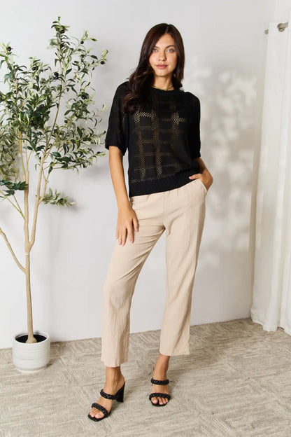 Black Mandy ribbed trim round neck knit top by Trendsi, featuring a close-up of the textured fabric and stylish neckline.