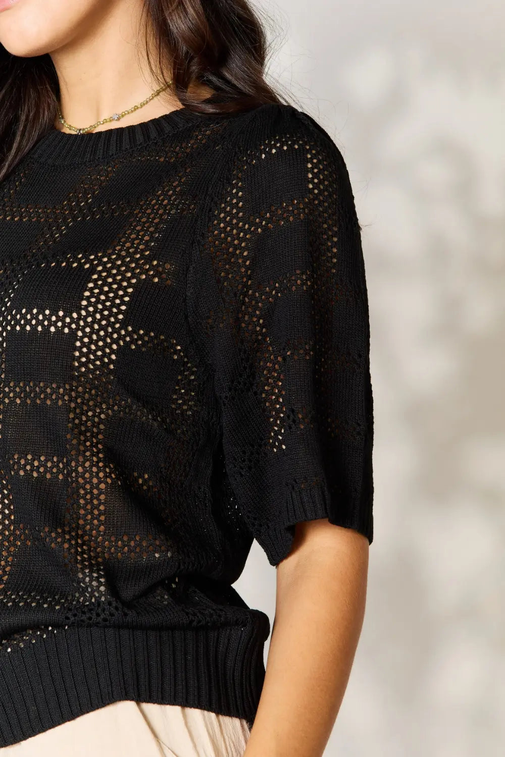 Black Mandy ribbed trim round neck knit top from Trendsi, showcasing a close-up of the textured fabric and classic neckline.