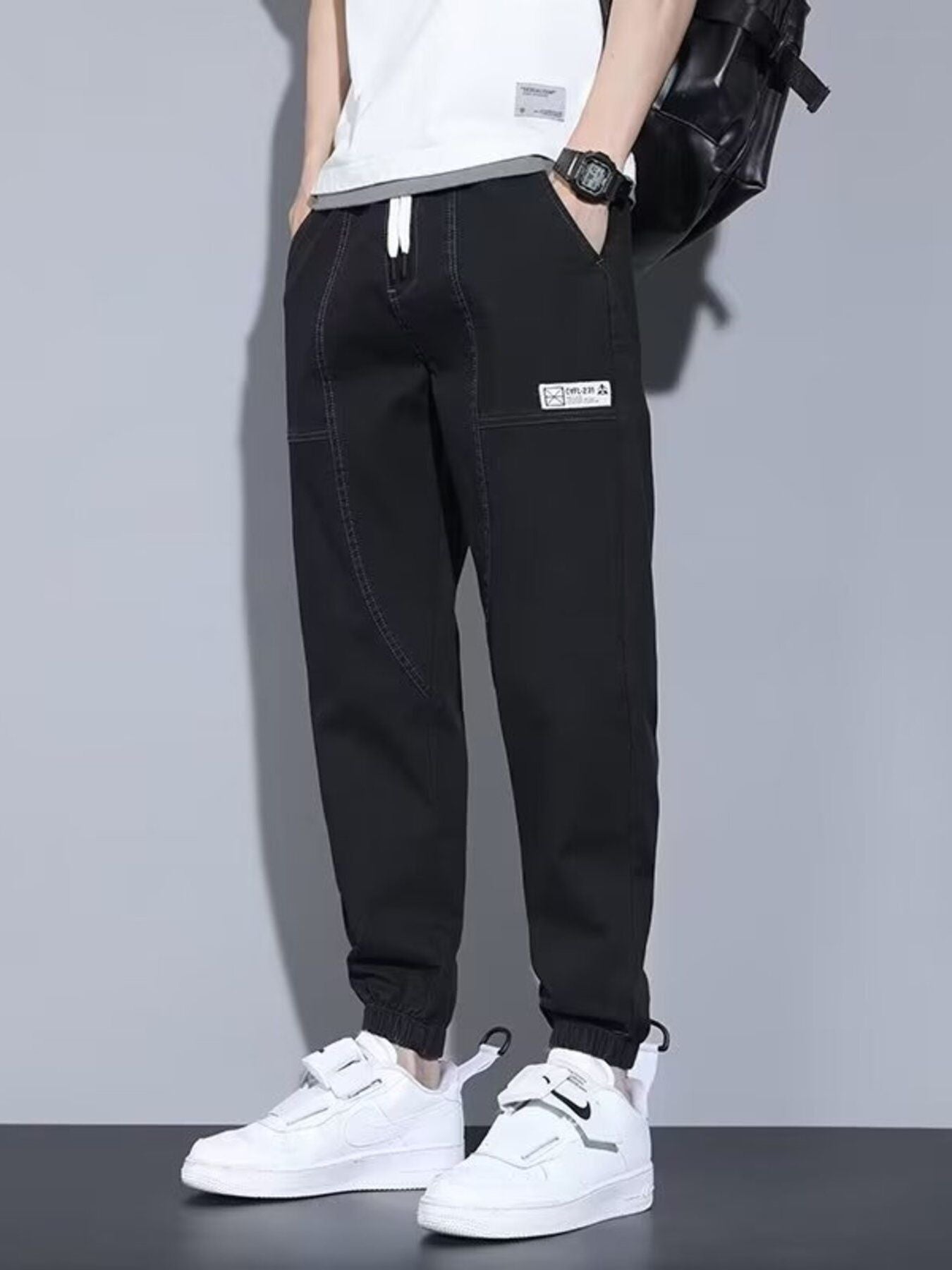 Men's black full-size casual denim joggers from Trendsi, loose fit plus size joggers, shown on a model.