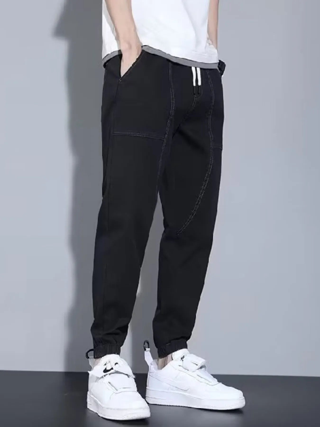 Men's black full-size casual denim joggers from Trendsi, loose fit, comfortable plus-size denim pants on a model.