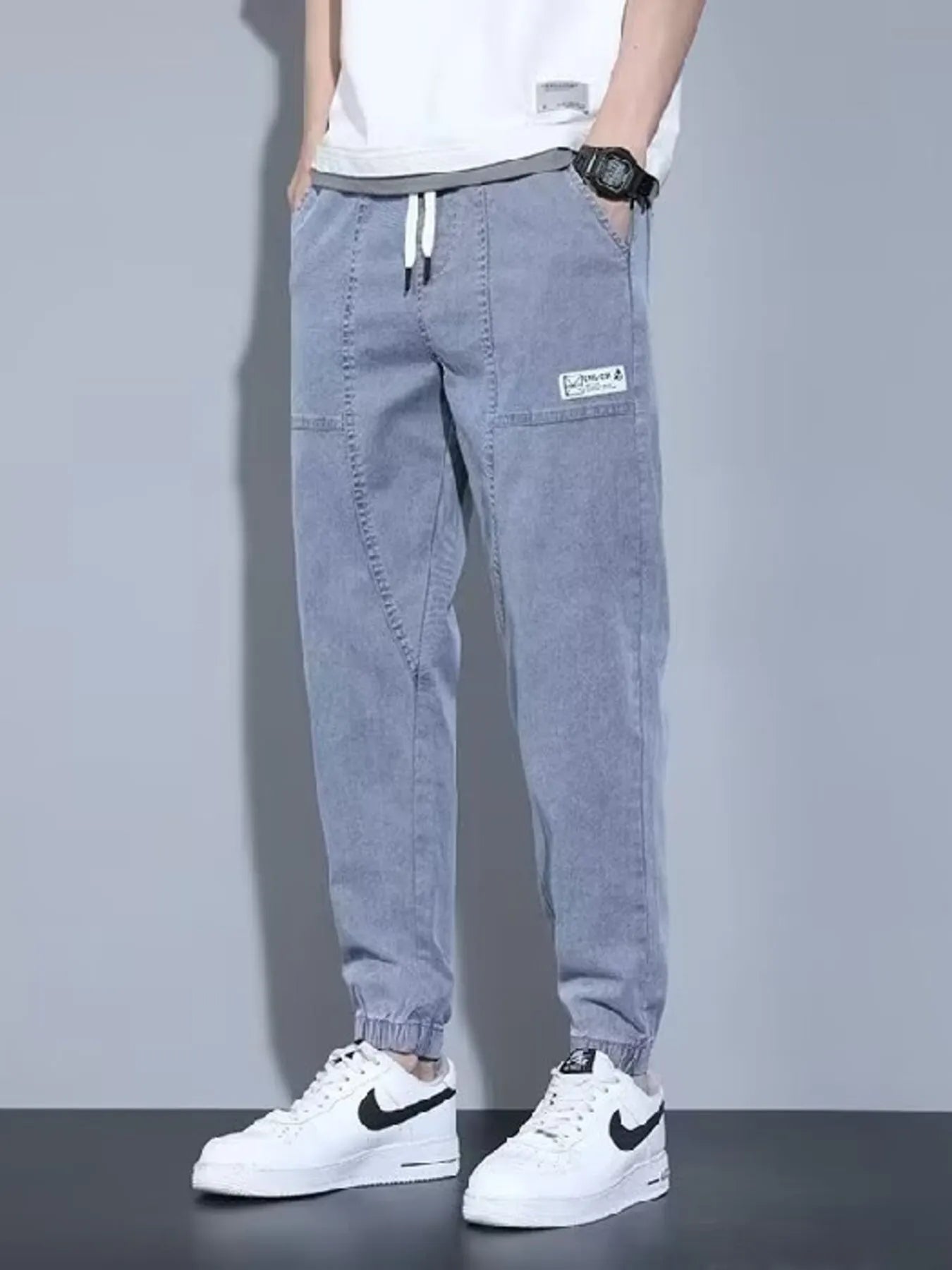 Men's black full-size casual denim joggers with a loose fit, plus size, by Trendsi, displayed on a model.