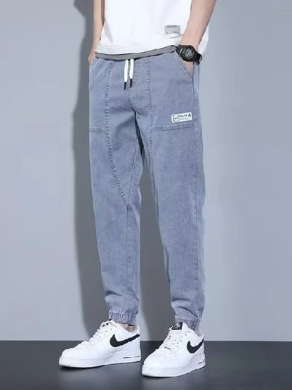 Men's black full-size casual denim joggers with a loose fit, plus size, by Trendsi, displayed on a model.