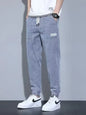 Men's black full-size casual denim joggers with a loose fit, plus size, by Trendsi, displayed on a model.