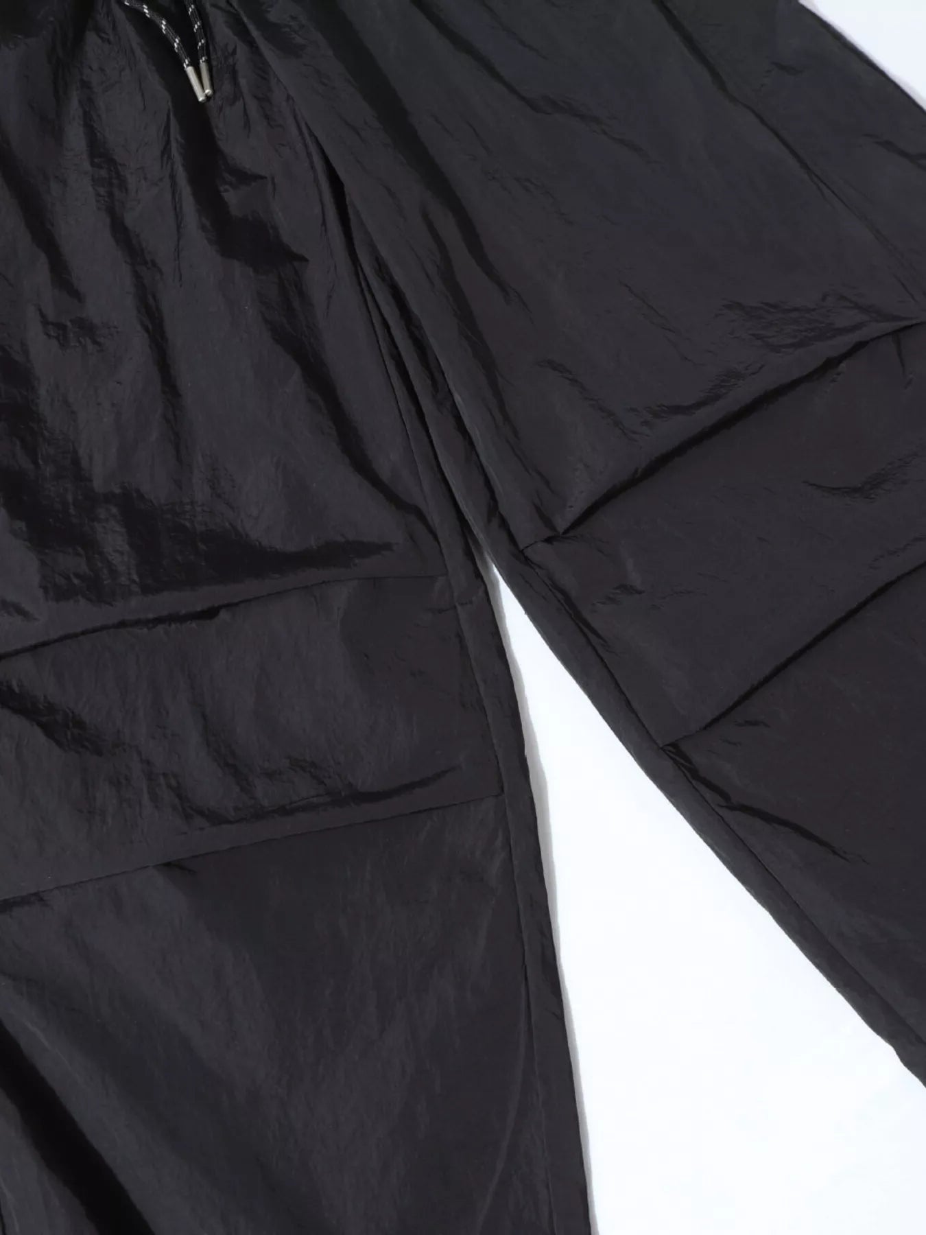Men's black wide-leg cargo pants by Trendsi, featuring multiple pockets and relaxed fit, shown on a model.