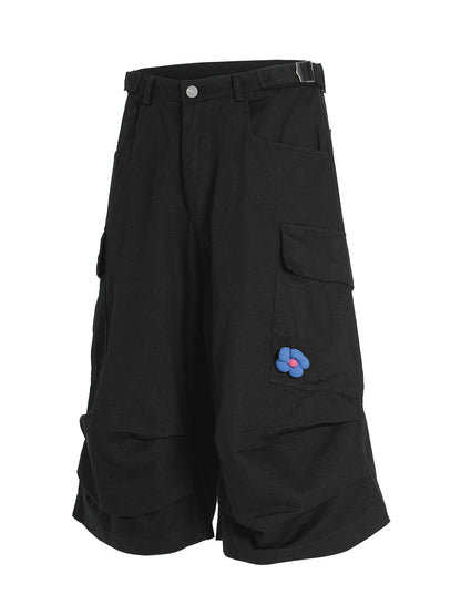 Men's black wide-leg cargo shorts with floral patch detail, from Trendsi, featuring multiple pockets and relaxed fit.