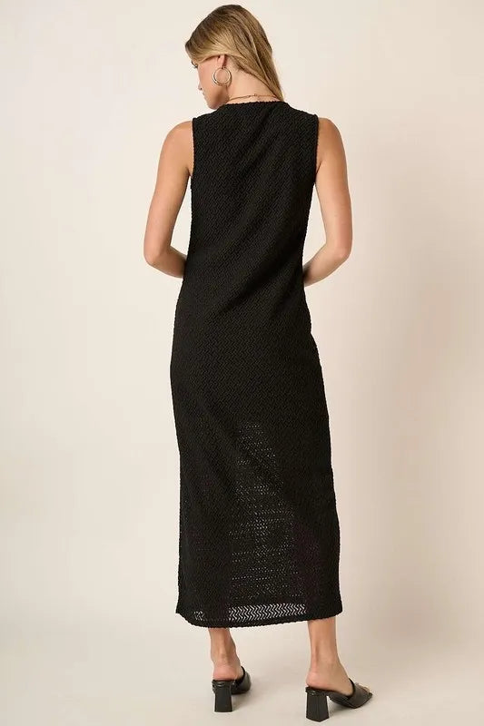 Black sleeveless dress by Trendsi with a round neck and side slit, featuring a stylish, casual design perfect for warm weather.