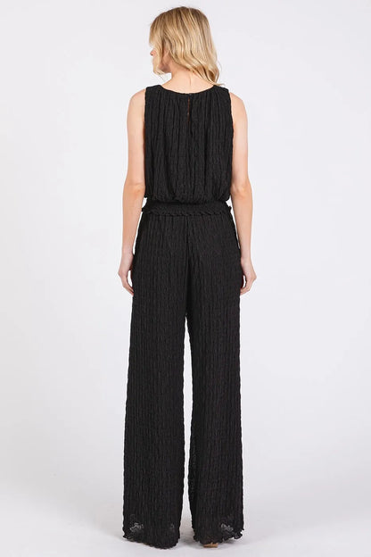 Black textured stretchy crop tank and pants set by Trendsi, featuring a fitted, comfortable design for casual wear.