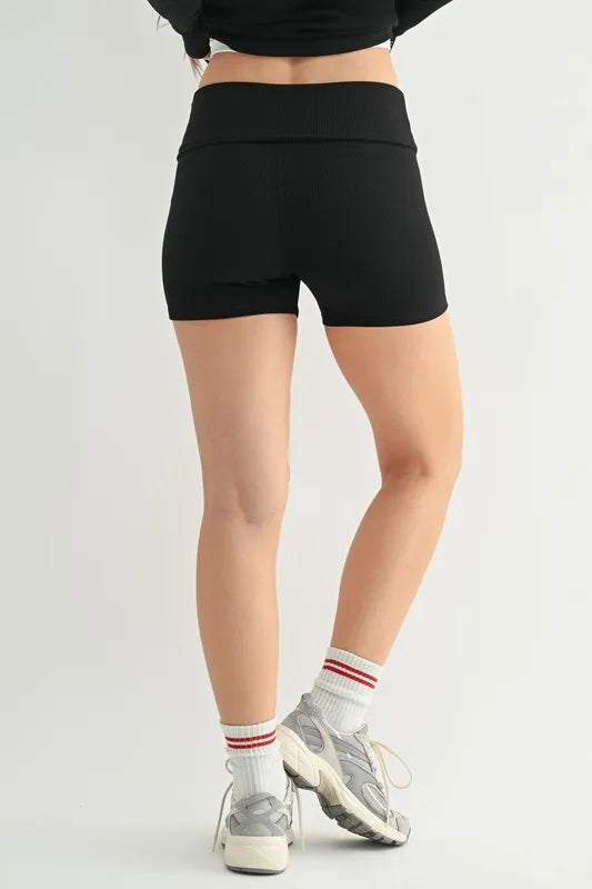 Black MONO B ribbed foldover waist shorts with a high-rise fit and comfortable stretch, shown on a model.