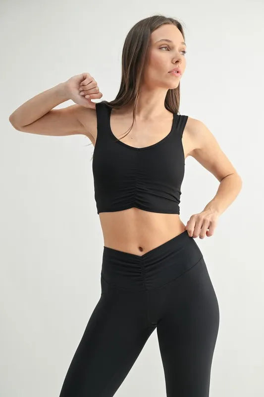 Black MONO B ruched front active tank top, fitted athletic style with adjustable straps, designed for comfortable active wear.