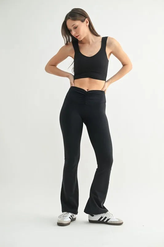 Black MONO B ruched front active tank top on a model, featuring a fitted design and sleeveless style for workout or casual wear.