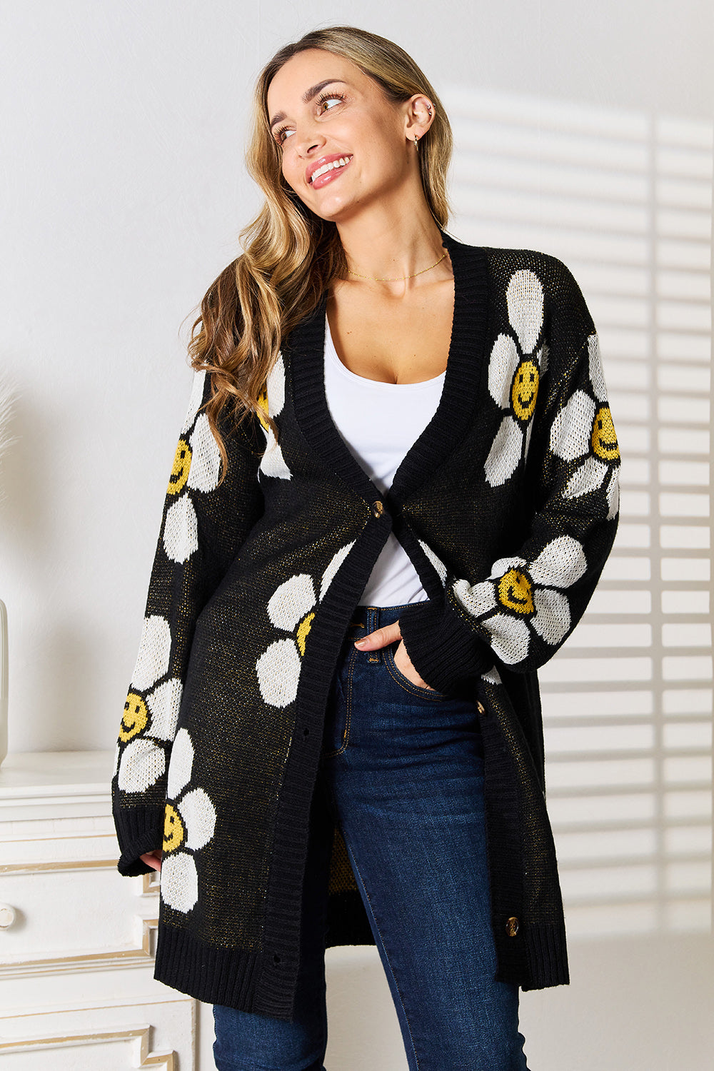 Black Perfee floral button-down longline cardigan from Trendsi, featuring a relaxed fit with colorful floral patterns.