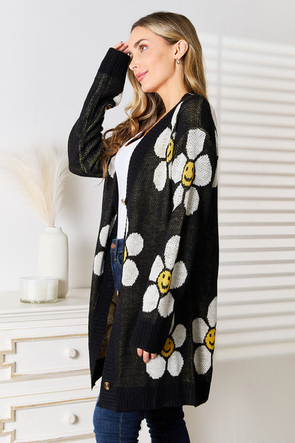 Black Perfee floral button-down longline cardigan by Trendsi, featuring a relaxed fit with floral pattern and front buttons.